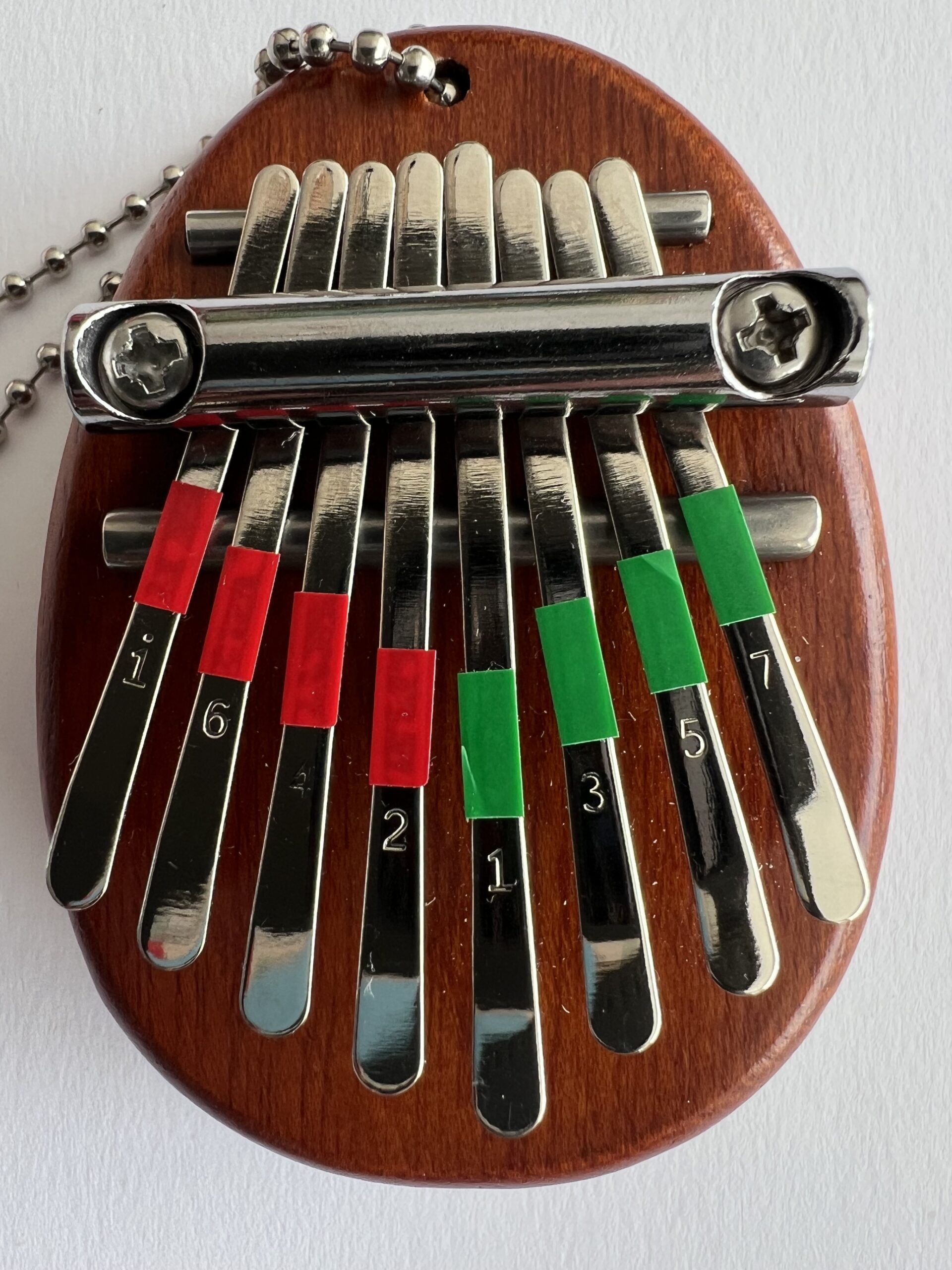 Rode en groene stickers op de toetsen van de mini-kalimba, voor aanduiding linker en rechter duim